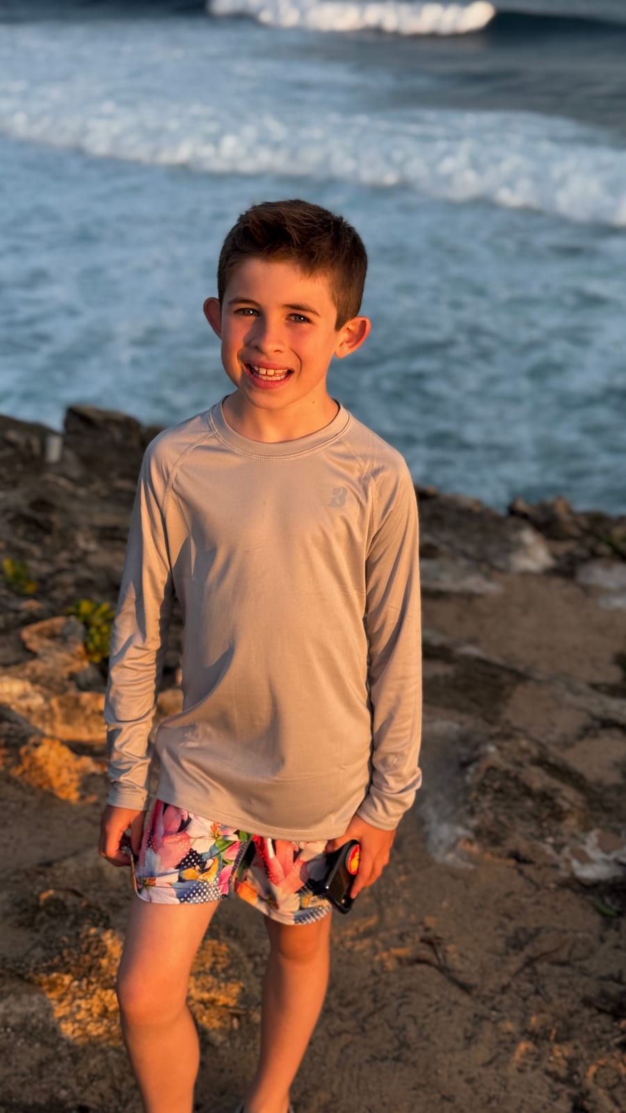 Landon smiling outdoors near the water